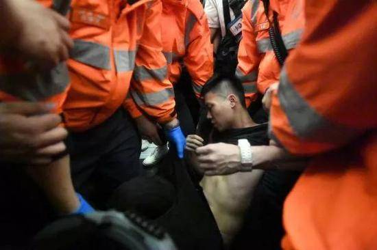 ▲8月13日，一名游客在香港机场被暴徒围殴。这是受伤游客被救护人员送离。（新华社）