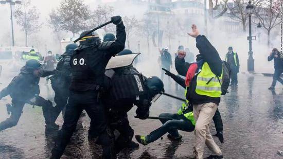 “黄背心”抗议活动现场，警方使用警棍“棒打”示威者。图源：CNN