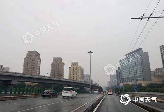 今晨，北京天空阴沉，雨水纷飞。（图/王晓）