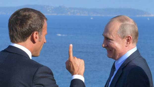 19日马克龙（左）与普京在法国会晤交谈（图源：路透社）