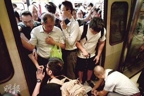 香港暴徒发起“不合作运动”，有人称雨伞掉落，须蹲下捡拾。图片来源：香港《明报》/赖俊杰摄