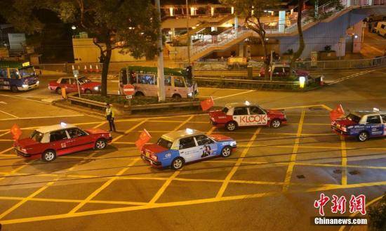 资料图：8月23日晚，“守护香港大联盟”联同香港的士司机从业员总会发起“守护香港·风雨同舟”大行动，在港岛筲箕湾中心，有超过140多辆出租车车身贴着海报，车尾悬挂五星红旗依次有序驶向主干道，呼吁社会反对暴力。中新社记者张炜摄