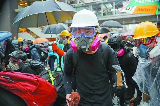 （青少年被卷入非法集会甚至充当“暴力先锋”的现象令香港社会忧虑。图为25日香港暴力示威中的年轻人。）