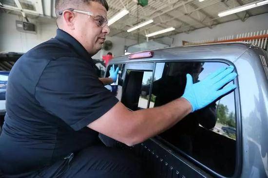 在美国俄亥俄州代顿的一家车行，一名工作人员将福耀玻璃装上一辆汽车。新华社记者张凤国摄