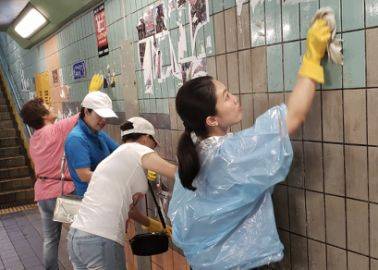 8月17日，欧阳凤盈和同伴在深水埗清理墙面。