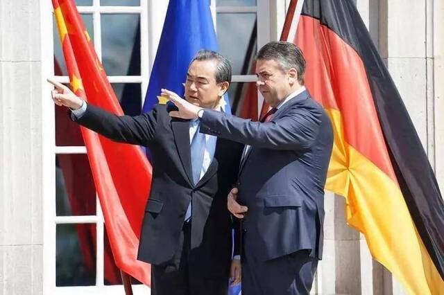 2017年4月26日，在柏林德国外交部的博尔西希别墅院内，外交部长王毅与德国副总理兼外长加布里尔在中德两国国旗和欧盟旗帜前合影。新华社记者王勍摄