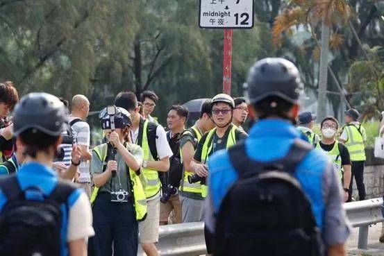 蓝衣传媒联络队员面对身穿黄色反光背心的记者。图源：香港警察传媒联络队