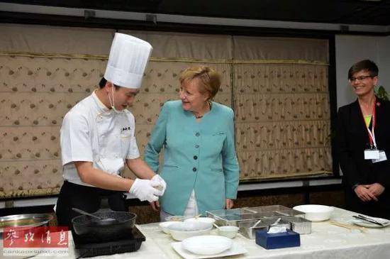 2014年7月，默克尔在成都映象餐厅学习川菜宫保鸡丁的做法（来源：新华社）