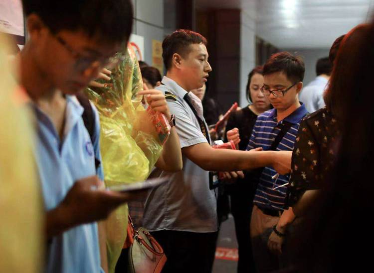 地铁10号线莲花桥站，工作人员为市民免费提供一次性雨衣。