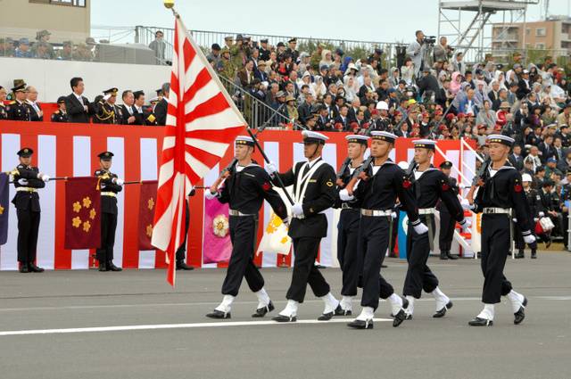 自卫队阅兵式上，海上自卫队队员手举“旭日旗”（朝日新闻）