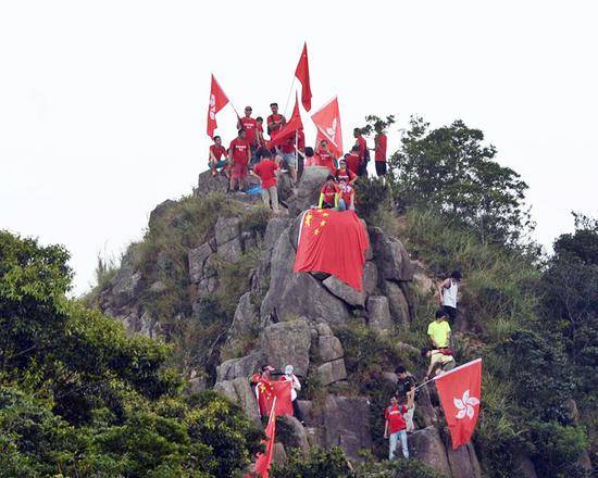 爱国团体登狮子山挥舞国旗 涉险摘除反对派标语