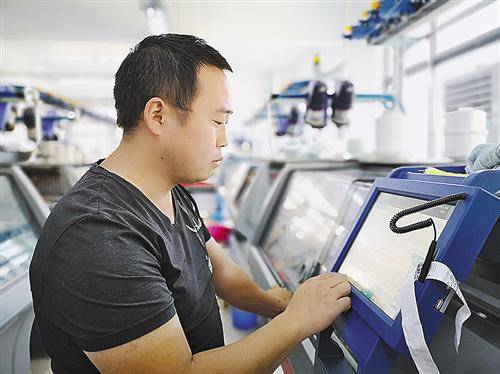 挡车工在智能织造车间操作一体成型无缝机。本报记者李哲摄