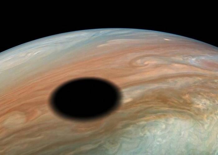 朱诺号探测器低飞木星拍下令人叹为观止的日偏食“木卫一”掠过木星表面