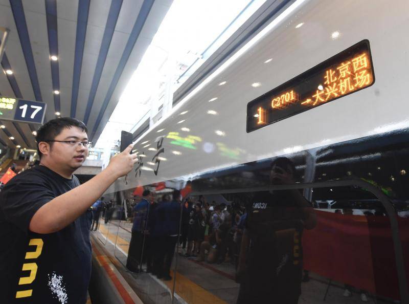 一位乘客在拍照北京西到大兴机场的C2701次列车。摄影/新京报记者吴宁