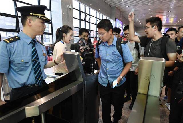 乘客在检票口有序排队，检票通过闸机。摄影/新京报记者吴宁
