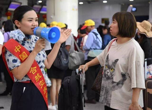  9月25日，北京南苑机场工作人员在引导旅客。新华社发（任超摄）