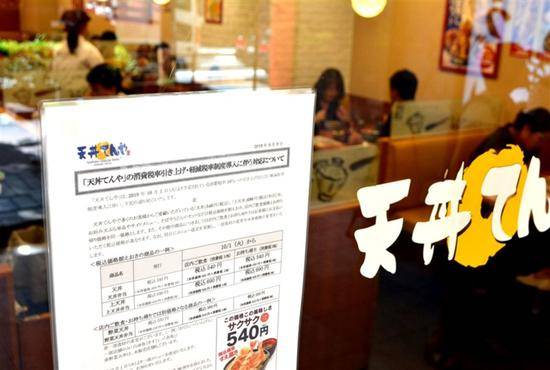 一家饮食店张贴告示向消费者说明增税后的食品价格。（图/西日本新闻社）