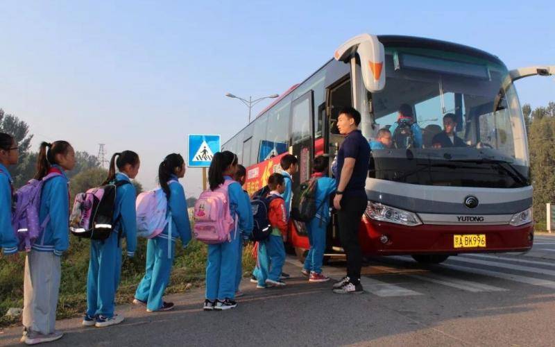 学生们有序地排队乘坐校车。平谷区供图