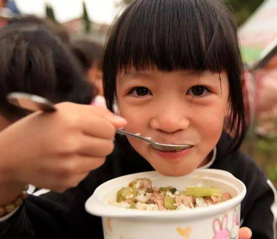 2011年11月9日，广西柳州市融安县大良镇中心小学，一名学生在吃免费午餐。（新华社记者谭凯兴摄）