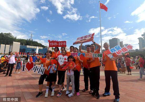 10月1日，福建省庆祝中华人民共和国成立70周年升国旗仪式在福州五一广场举行。图为参加升国旗仪式的学生和国旗合影留念。（视觉中国）