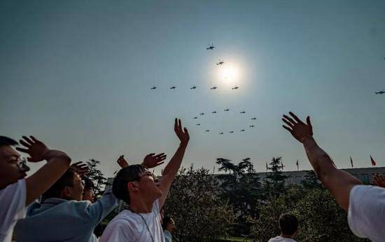 这是群众向在空中组成“70”字样的20架直升机挥手致意。新华社记者江文耀摄