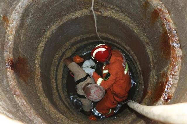 云南景谷1工人作业时遭落石击中被困井底，消防下井救人