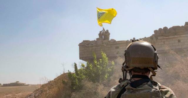 9月26日，一名美军士兵注视YPG在一处据点升旗图源：SDF