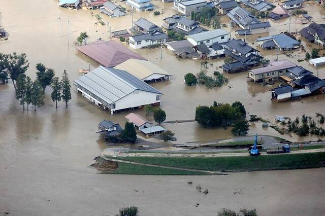 10月13日，在日本长野县，千曲川河水侵袭住宅区。新华社图