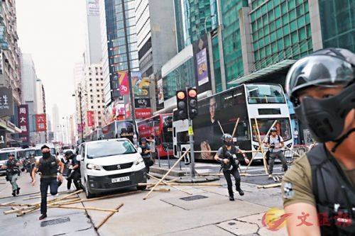 香港警察冲破旺角弥敦道的路障，下车拘捕多名涉嫌堵路的蒙面暴徒。（香港文汇报）