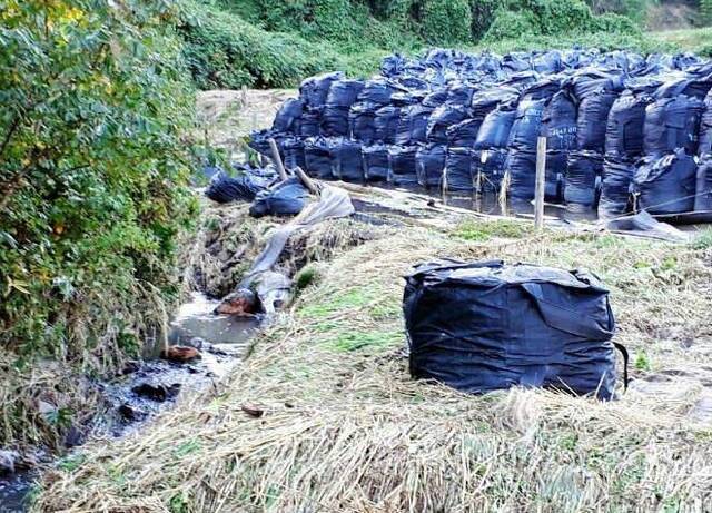 装有核污染土壤的除污袋被大雨冲散。图片来源：朝日新闻