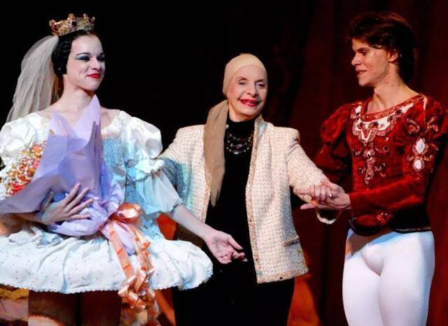 2004年1月24日，古巴国家芭蕾舞团团长阿莉西亚·阿隆索（中）在北京人民大会堂上演的世界芭蕾舞坛经典杰作《天鹅湖》演出结束后，在两位主要演员的陪同下向现场观众谢幕。新华社记者陈建力摄