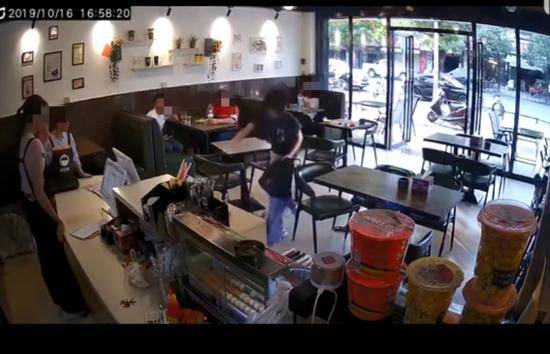 视频显示，一名短发女子在一店内将另一女子推倒并踢打。网络视频截图