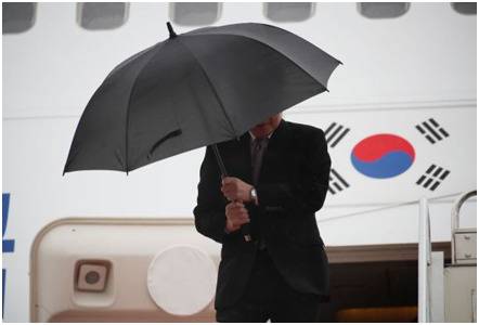 强风袭来，李洛渊双手紧握雨伞图源：《国民日报》