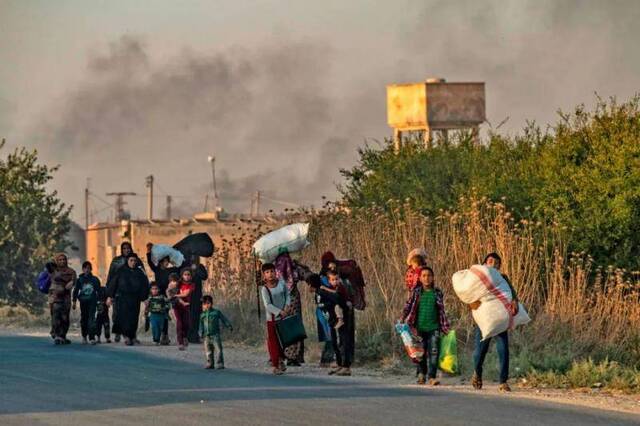 10月9日，在叙利亚东北部哈塞克省拉斯艾因，当地民众从战区撤离。新华社/法新