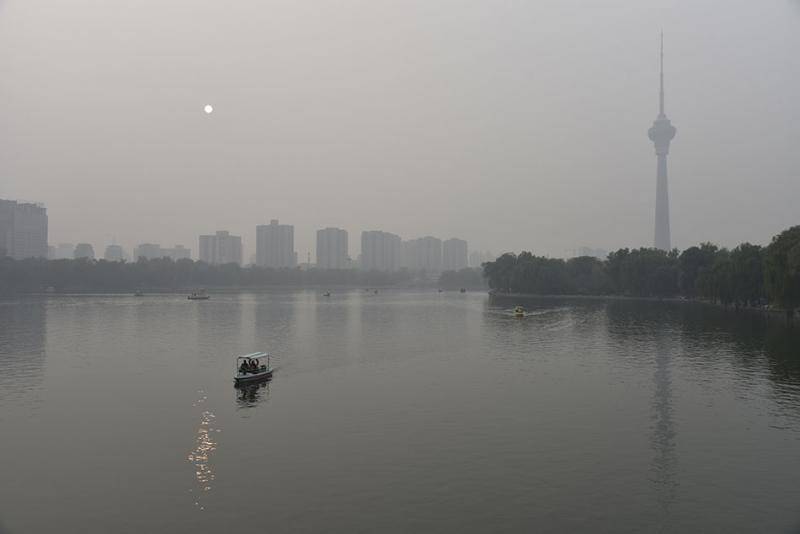  10月19日，北京陷入一片雾霾之中，从玉渊潭公园看中央广播电视塔和太阳。 ICphoto图