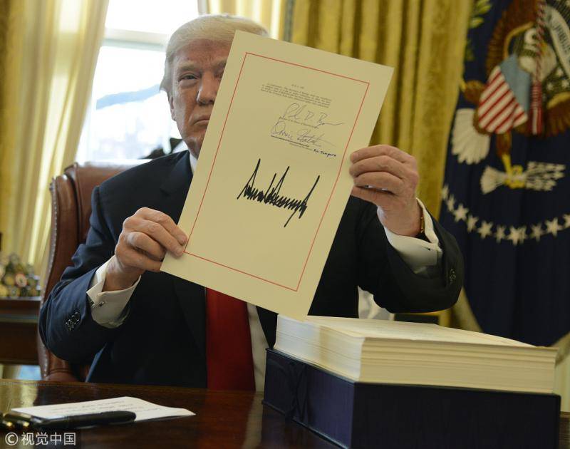 2017年12月22日，特朗普在白宫签署税改法案图自视觉中国