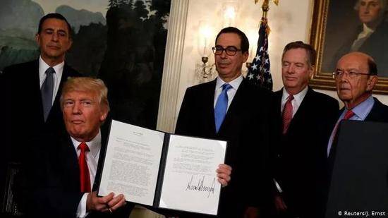  U.S。 President Donald Trump， holds the signed memorandum directing the U.S。 Trade Representative to start the review of trade issues with China at the White House in Washington， U.S。 August 14， 2017。/ Reuters