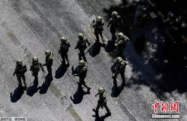 资料图：当地时间10月30日，防暴警察在圣地亚哥的智利总统府周围。