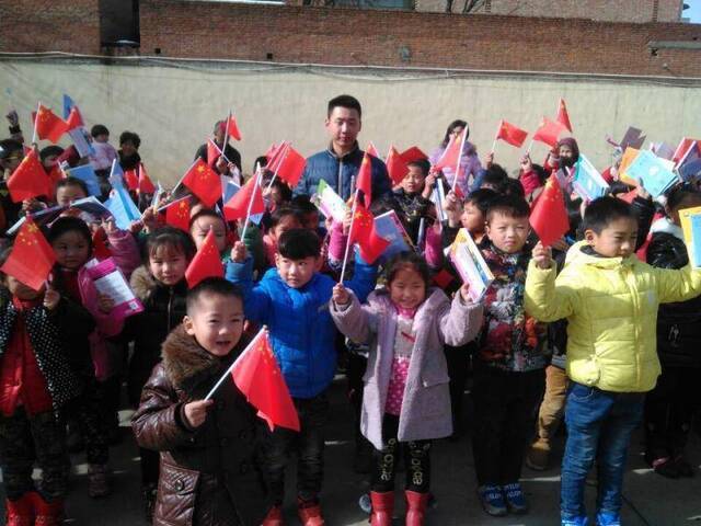 ▲吴景硕为洛阳市丰李镇东军屯小学学生送去书籍和小红旗