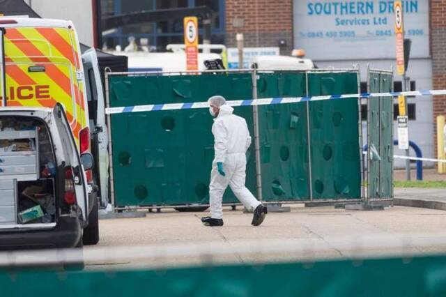 10月23日，在英国埃塞克斯郡一个工业园区内，一名法医在发现遗体的集装箱货车附近工作。新华社发（雷伊·唐摄）