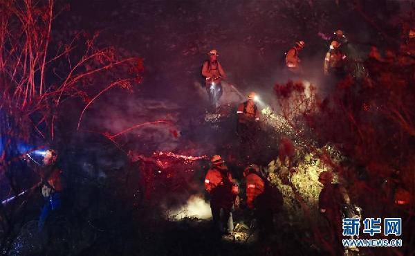 10月30日，在美国加利福尼亚州富勒顿市，消防员在火场工作。近日，美国加利福尼亚州山火持续肆虐，大量居民被迫撤离。新华社记者李颖摄
