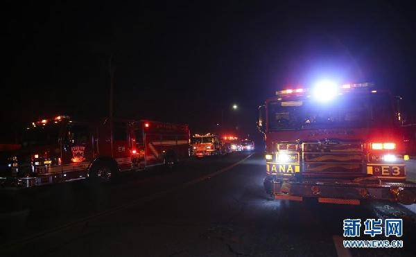 10月30日，在美国加利福尼亚州富勒顿市，消防车在火场附近待命。近日，美国加利福尼亚州山火持续肆虐，大量居民被迫撤离。新华社记者李颖摄