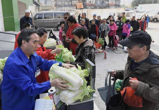 市民在冬储蔬菜销售点前排起长队。摄影/新京报记者吴宁