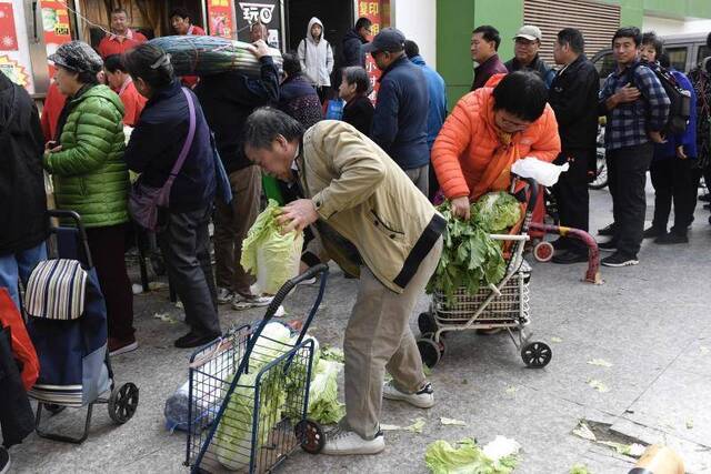 周边居民用小车运走冬储大白菜。摄影/新京报记者吴宁