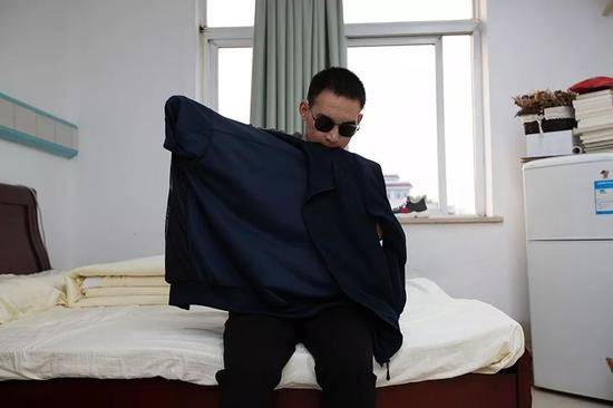 2019年10月24日，重庆西南医院康复楼，清晨，杜富国洗漱完毕后独自穿衣服。新京报记者李凯祥摄