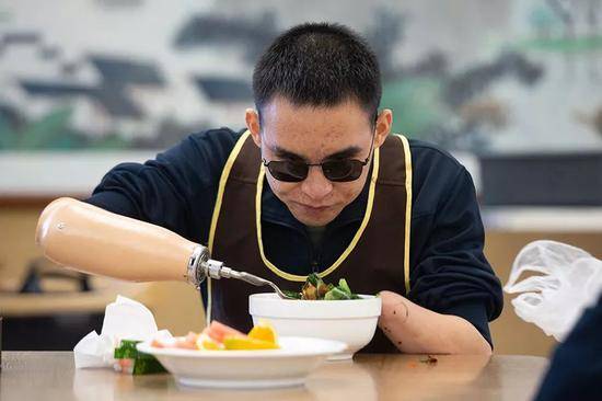 2019年10月24日，重庆西南医院康复楼，杜富国正在用辅助具吃饭。新京报记者李凯祥摄