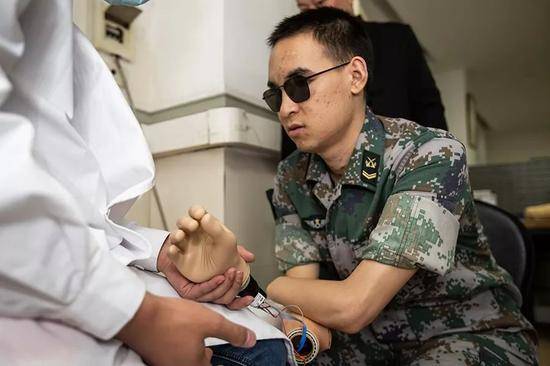 2019年10月23日，重庆西南医院康复楼，杜富国尝试将智能手穿戴到胳膊上。新京报记者李凯祥摄
