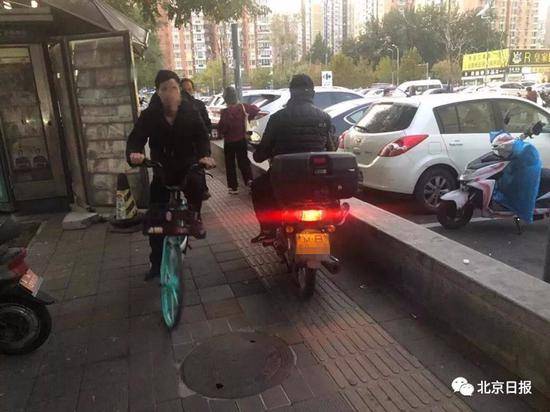 广渠路一家乐福超市门前京B号牌摩托车便道行驶。