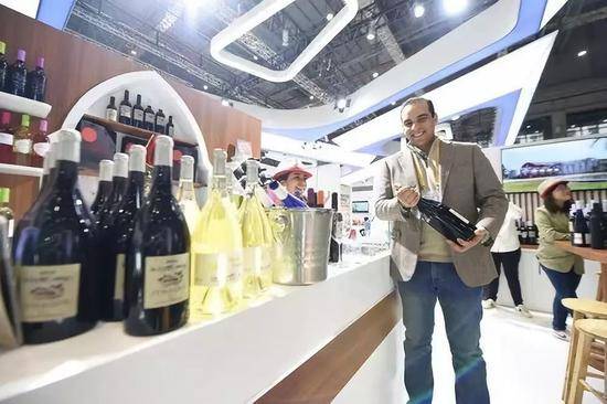  11月7日，在第二届进博会上，摩洛哥红农场酒庄总经理马蒙·萨耶展示红酒。新华社记者尹炣摄
