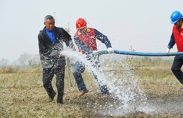 2019年11月4日，安徽滁州，明光市潘村镇太平村，“红马甲”电力党员服务队队员和农民一起使用抽水机械为农田灌溉，减少旱情对冬小麦的影响。视觉中国图